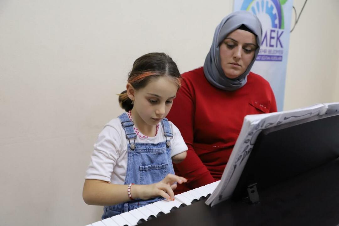 Zeynep, che non è nata con il braccio sinistro, è sorretta dalla madre.