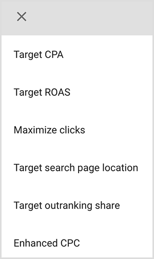 Questo è uno screenshot di un menu di opzioni di targeting in Google Ads. Le opzioni sono CPA target, Ritorno sulla spesa pubblicitaria target, Massimizza i clic, Targeting della posizione della pagina di ricerca, Quota superamento target, CPC ottimizzato. Mike Rhodes afferma che le opzioni di targeting intelligente in Google Ads utilizzano l'intelligenza artificiale per trovare persone con il giusto intento per il tuo annuncio.